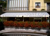 Tenda da sole in tessuto resinato anti-pioggia, con movimentazione elettrica e telecomando. Anno 2008.